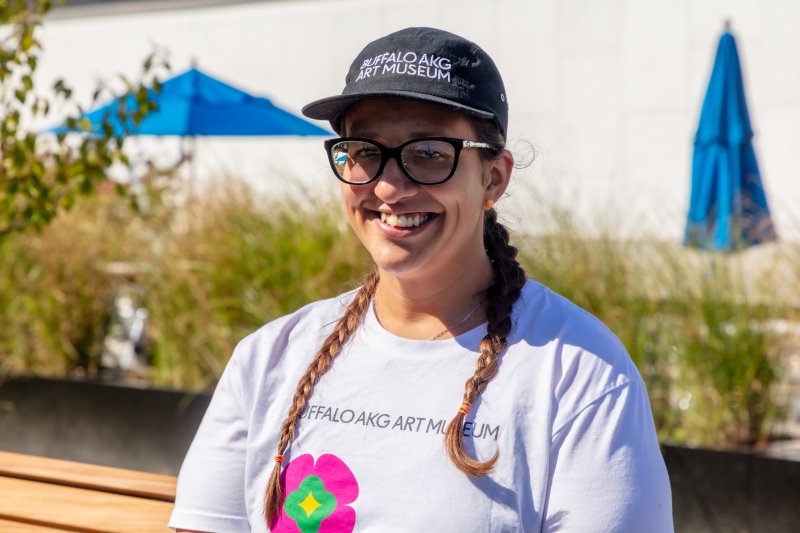 A woman wearing a hat and glasses with long braids