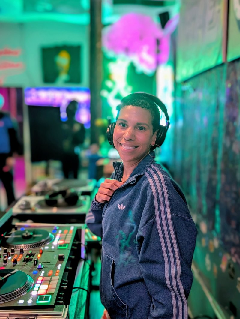 A DJ smiling with their equipment