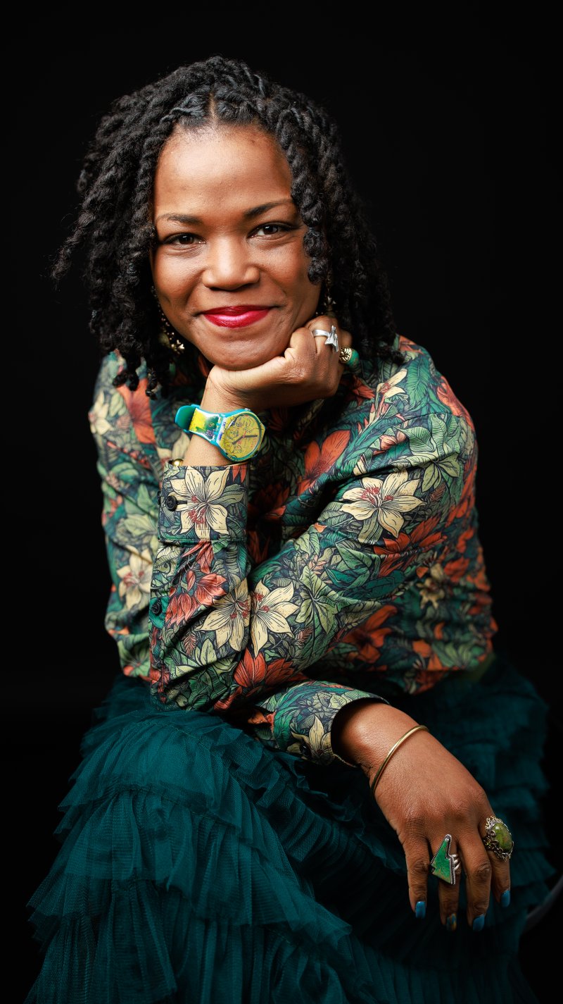 A woman with a colorful shirt sitting in a green chair