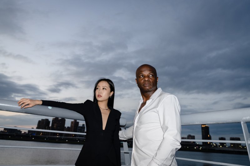 Two people looking in opposite directions with a cityscape in the background