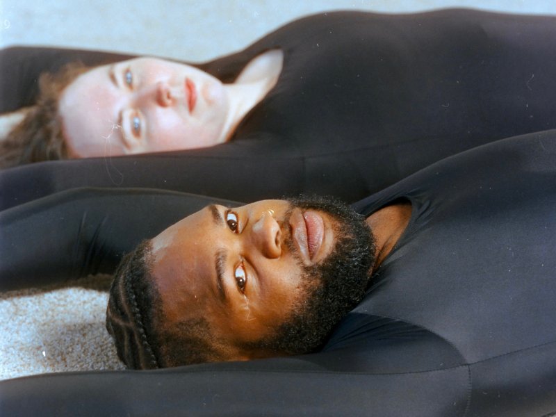 A close view of man and a woman laying on their backs wearing black clothes