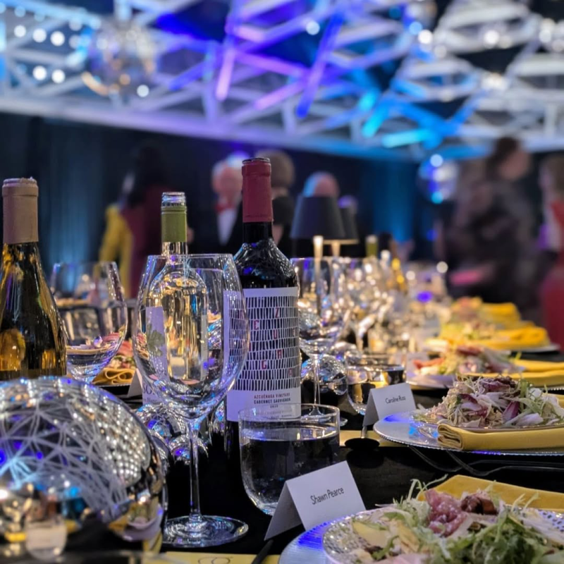 Wine bottle on a table with wine glasses and table settings around it
