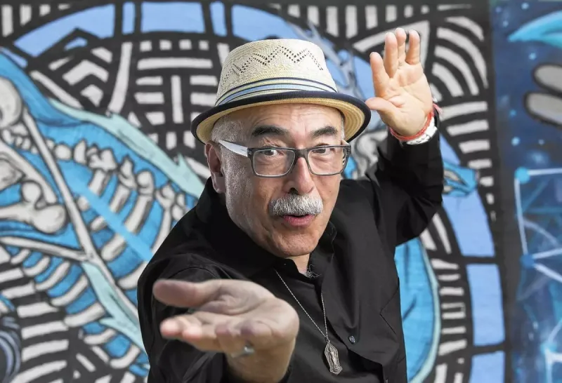 Juan Felipe Herrera in front of a colorful mural background