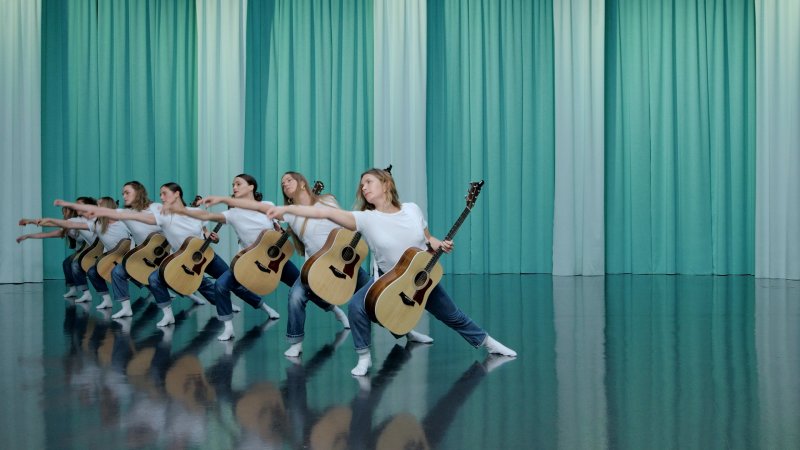 A group of dancers with acoustic guitars