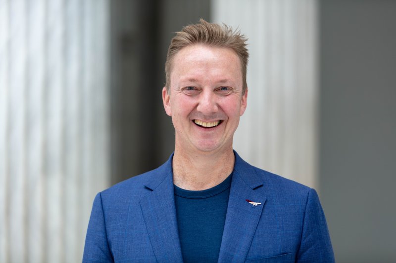 A person in a blue suit smiling 
