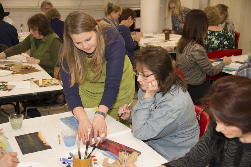 Teacher guiding an adult student in an art class