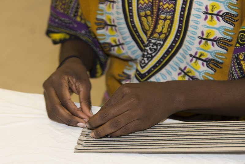 Hands of an African American girl creating art on a table