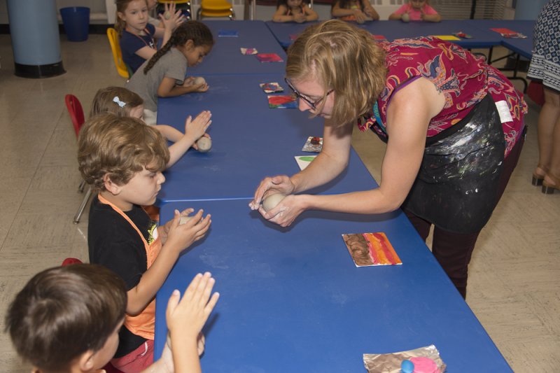 Children learning about clay form an AK educator