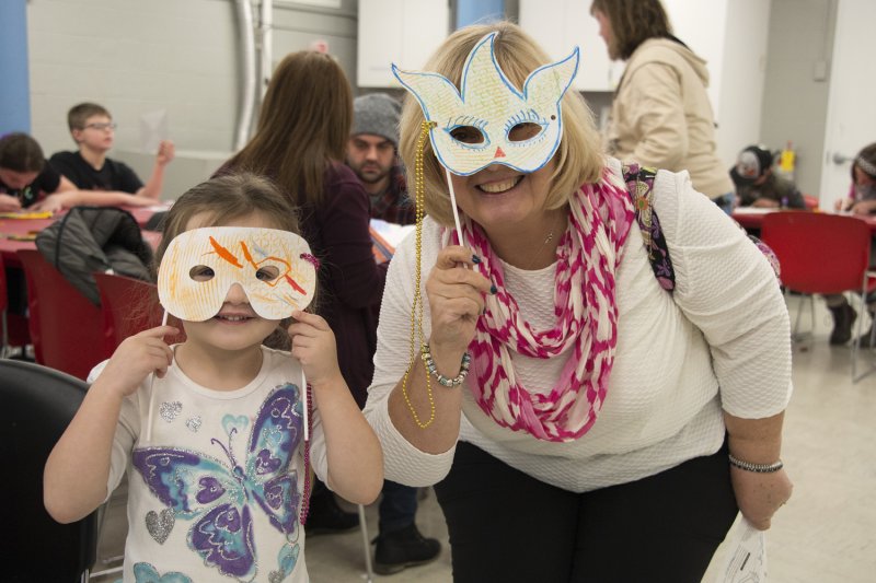 Mom and daughter holding up masks they created