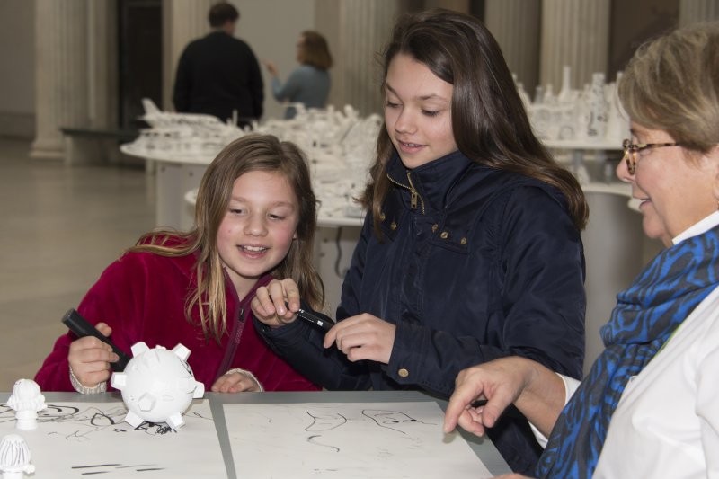Two girls and a docent exploring materials on the ArtCart