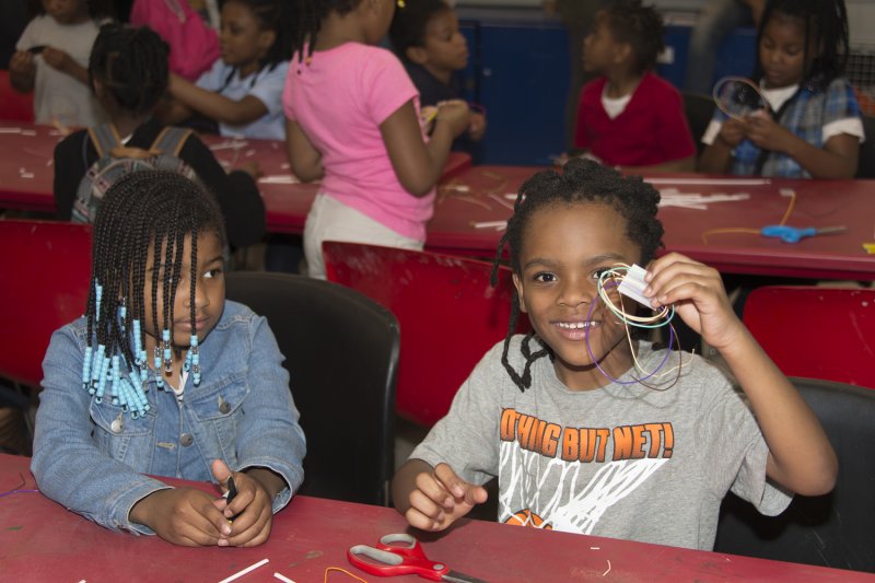 Two young girls making art in the classroom