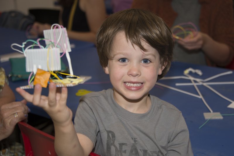 A boy holding a paper sculpture