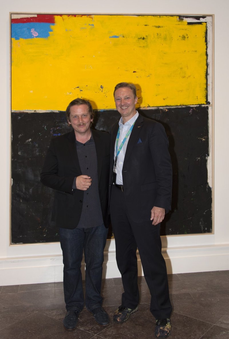 Joe Bradley with Peggy Pierce Elfvin Director Janne Sirén in front of Bradley's painting Good World, 2017