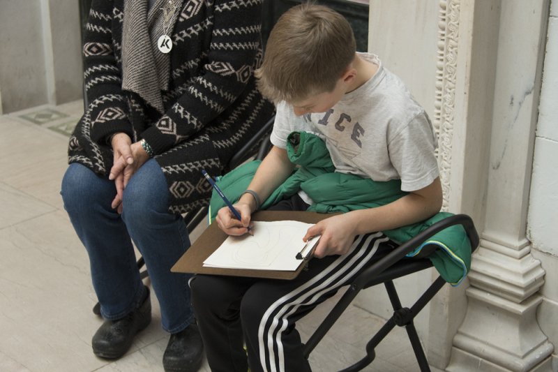 A boy drawing in the Sculpture Court
