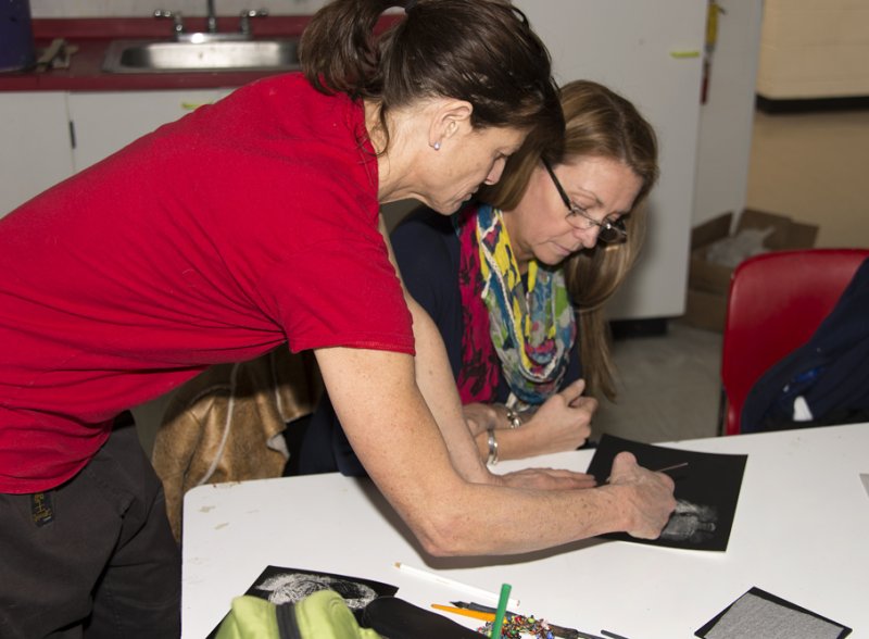 A teacher helps an adult student in the classroom