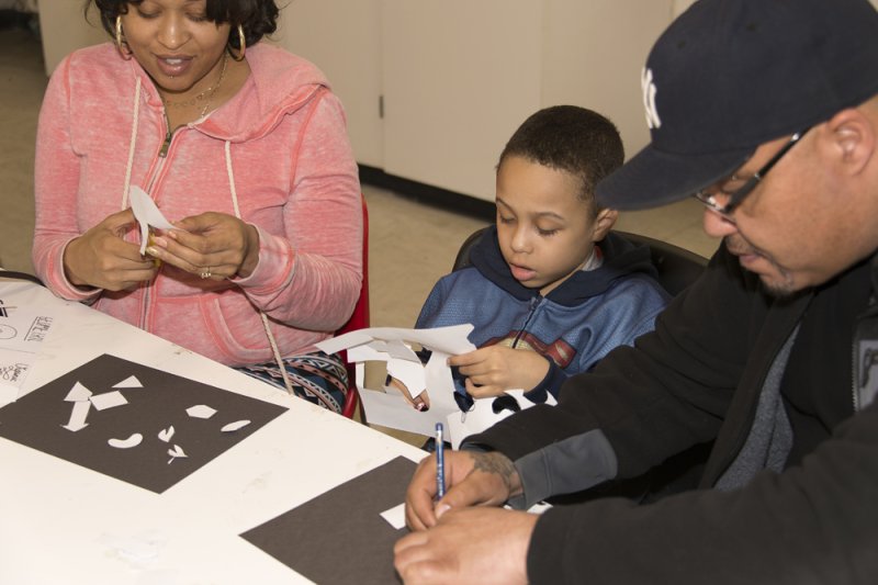 Family cutting paper in the classroom