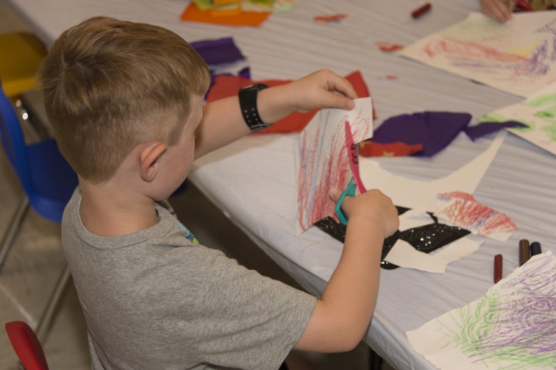 A young boy drawing in the classroom
