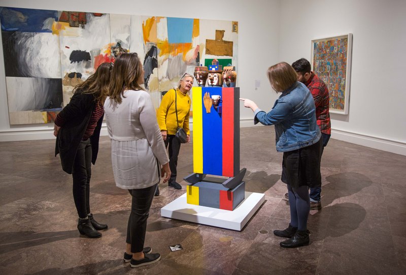 Adults looking at Marisol's Tea for Three sculpture
