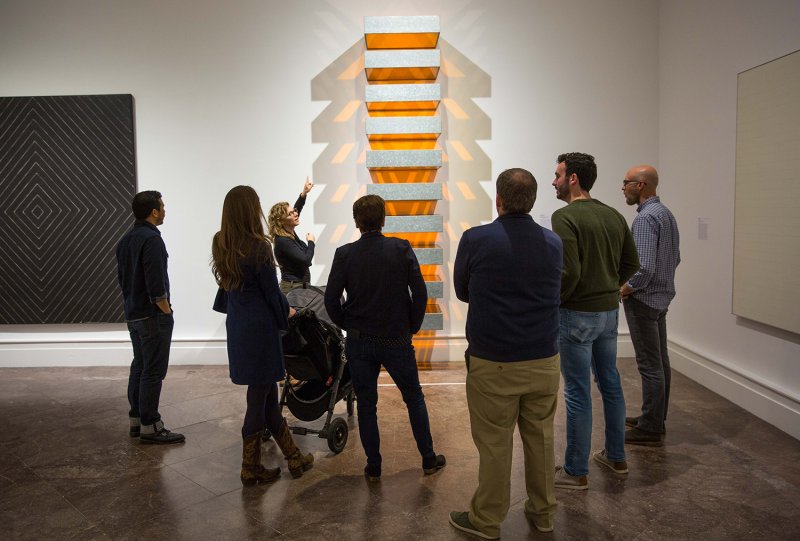 A group of adults looking at Donald Judd's untitled sculpture