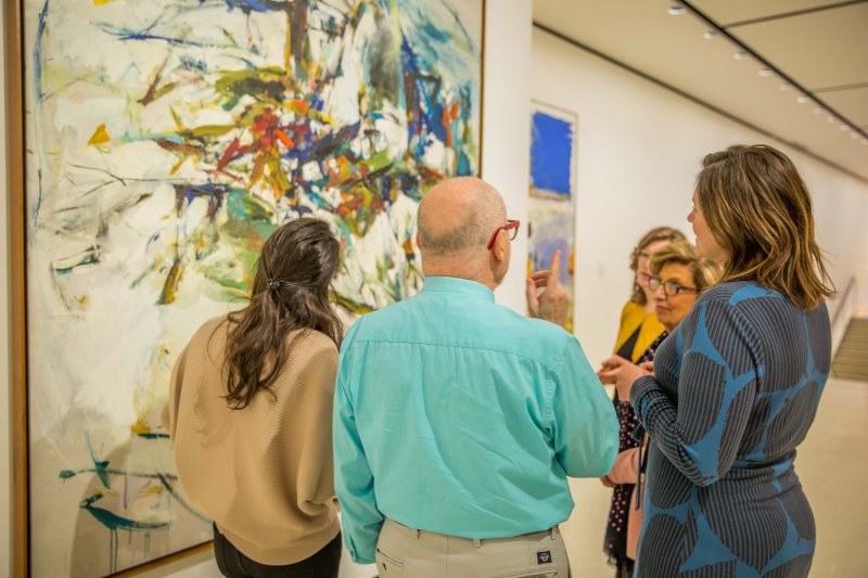 A group of adults on a tour in front of Joan Mitchell's George Went Swimming at Barnes Hole but Got too Cold