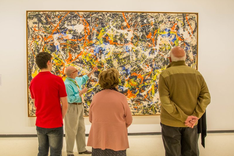 Docent John D’Arcangelo leads a tour in front of Jackson Pollock's Convergence, 1952