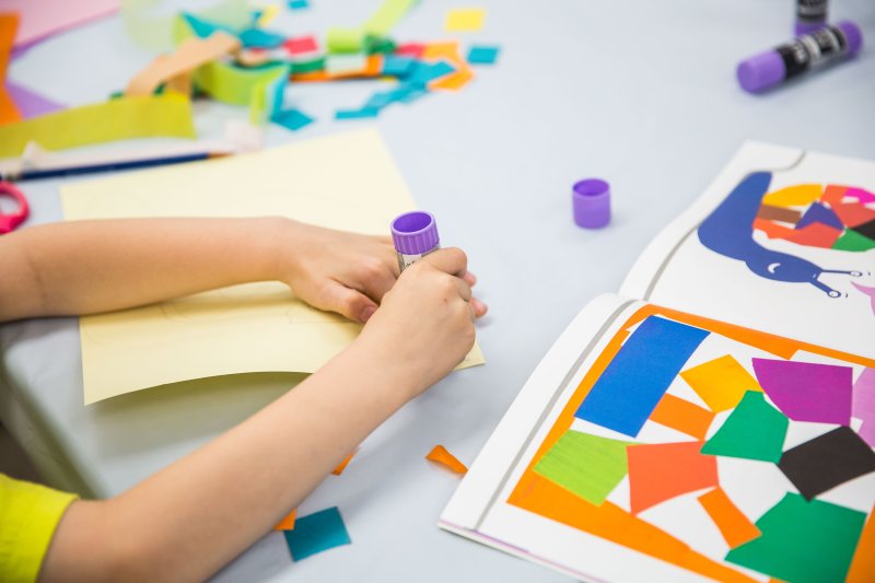 A kid creating a collage in the classroom