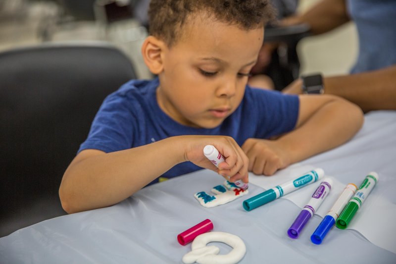 A boy coloring 3D letters in the classroom