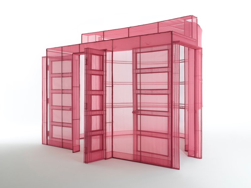 A sculpture of a room made from transparent red gauze