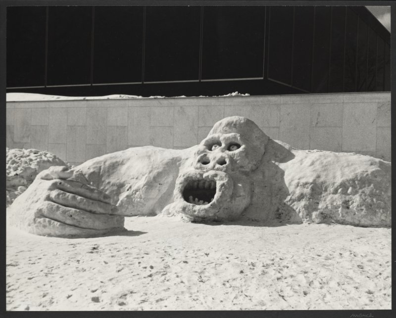 Snow sculpture of a monster with wide eyes and open mouth