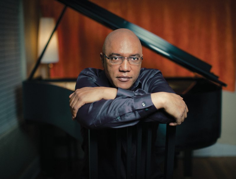 Billy Childs sitting in front of a piano