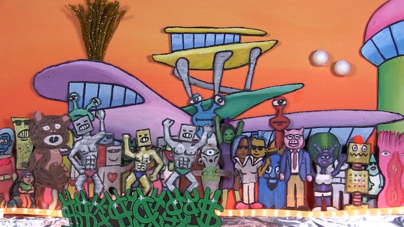 A still frame from an animated film showing a variety of colorful alien creatures with a whimsical spacecraft in the back