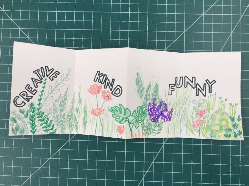 An accordion book with colorful flowers and the words "creative," "kind," and "funny"
