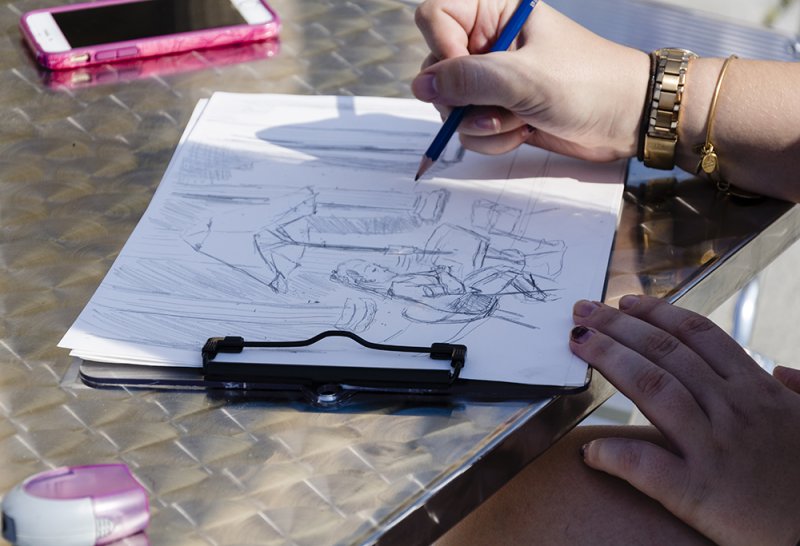 An AK visitor works on a drawing
