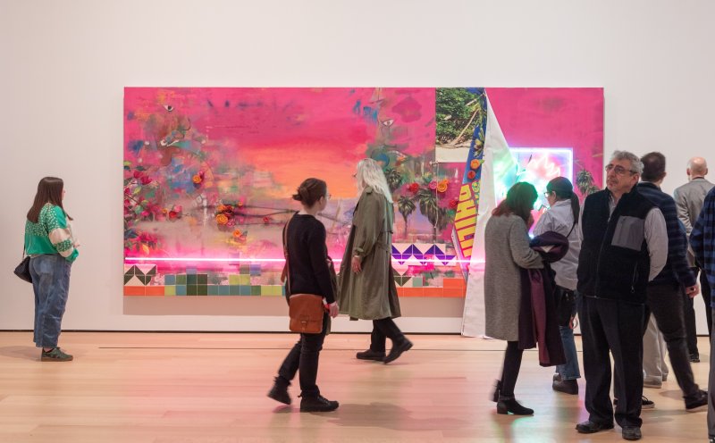 Visitors in front of a vibrant artwork by artist Patrick Martinez
