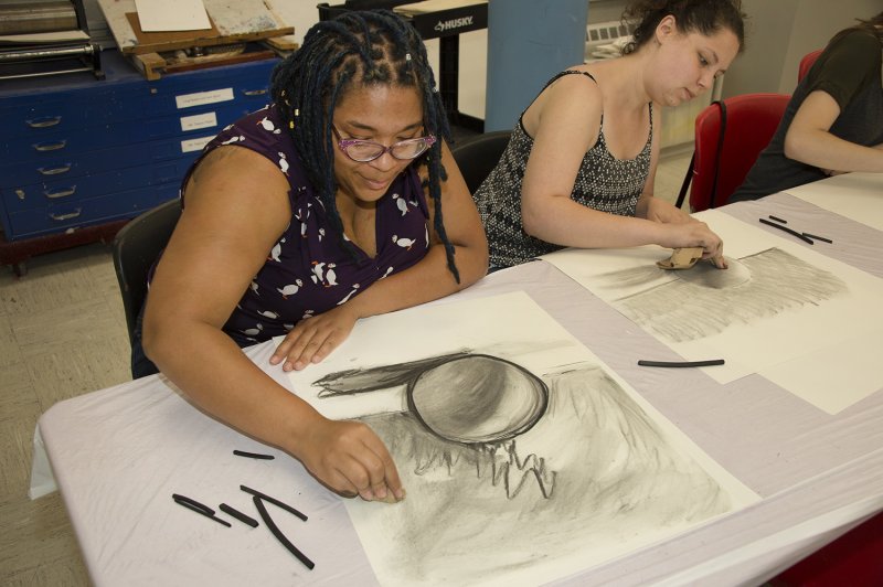 Two adult women drawing in the classroom