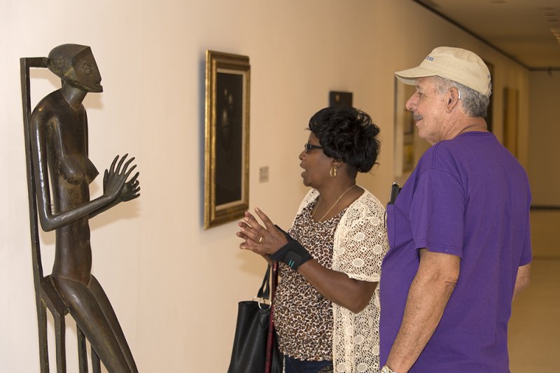 A woman and man look at a sculpture by Alberto Giacometi