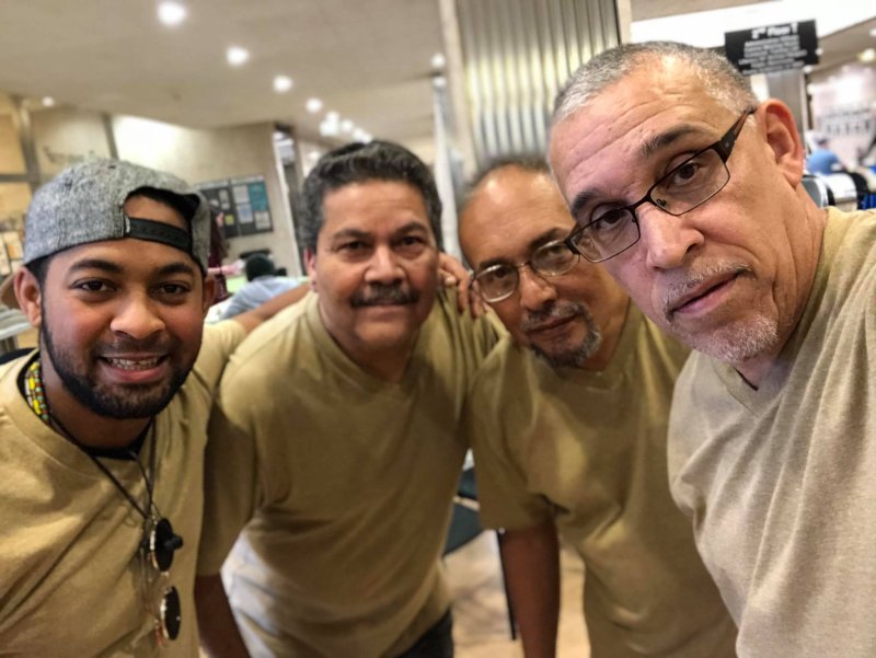 Four Latino men in beige t-shirts