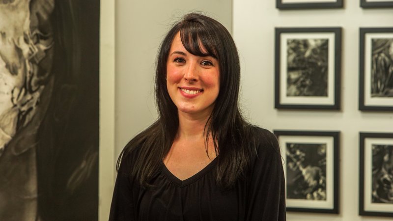 A woman with long brown hair wearing a black shirt