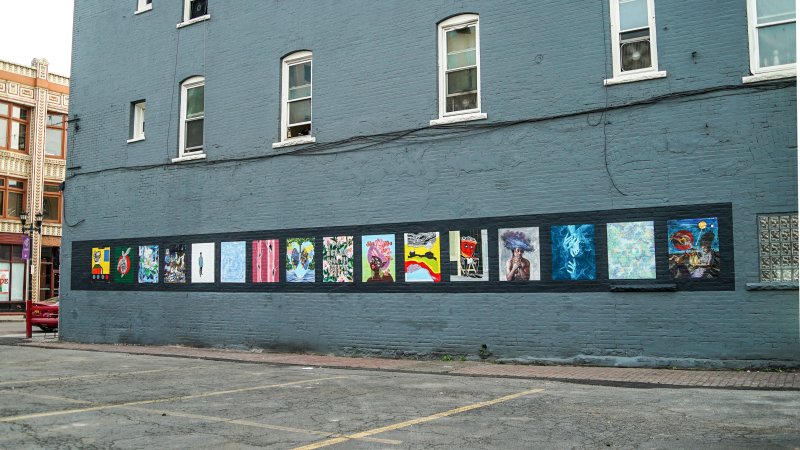 The side of a building with sixteen paintings affixed to it
