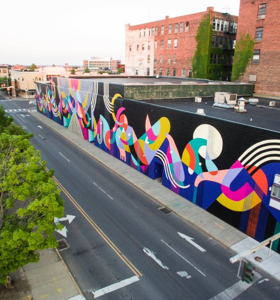 A aerial view of a colorful mural featuring many shapes in different colors on a black background