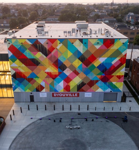 Aerial view of building with multicolor mural in cross-checked pattern across one side