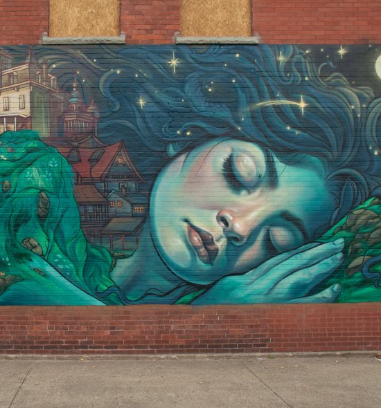 Closeup of a mural of a blue sleeping giantess