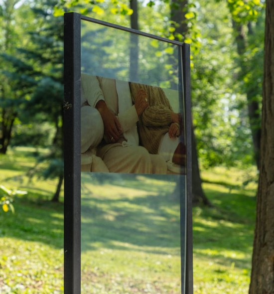 A glass sign with an image of hands in an embrace