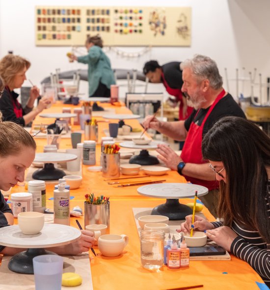 Adults participating in a pottery class