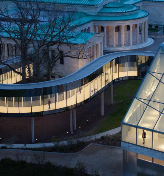 Aerial view of a bridge connecting a traditional marble museum building to a modern one
