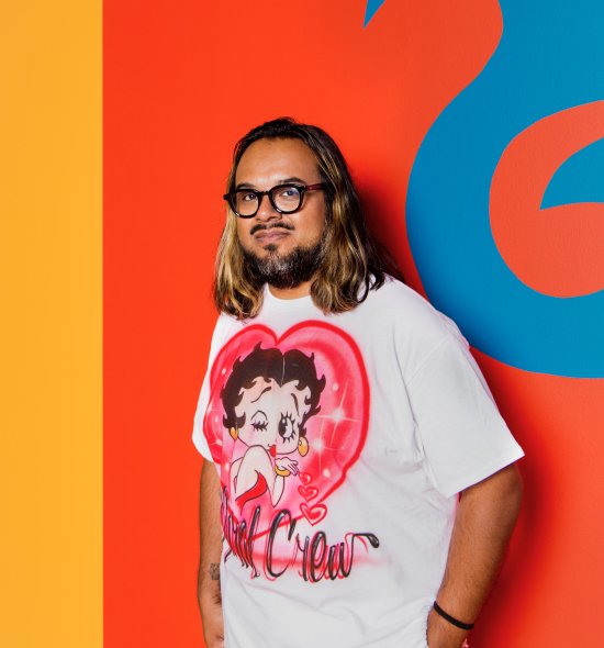 A person standing in front of a vibrant painting 