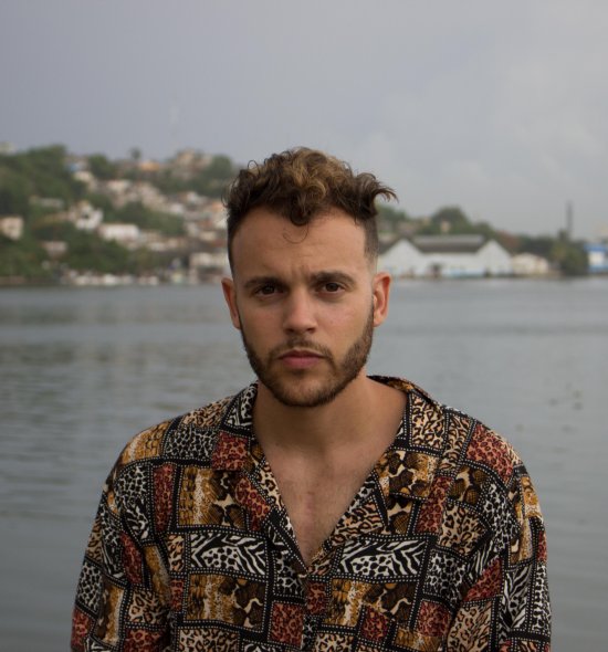 A person in an animal print shirt with a body of water in the background