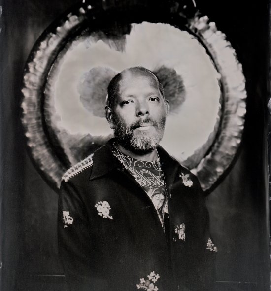 Tin type black and white photo of a person with a dark floral shirt