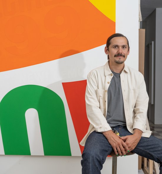 A person sitting in front of a large vibrant abstract work