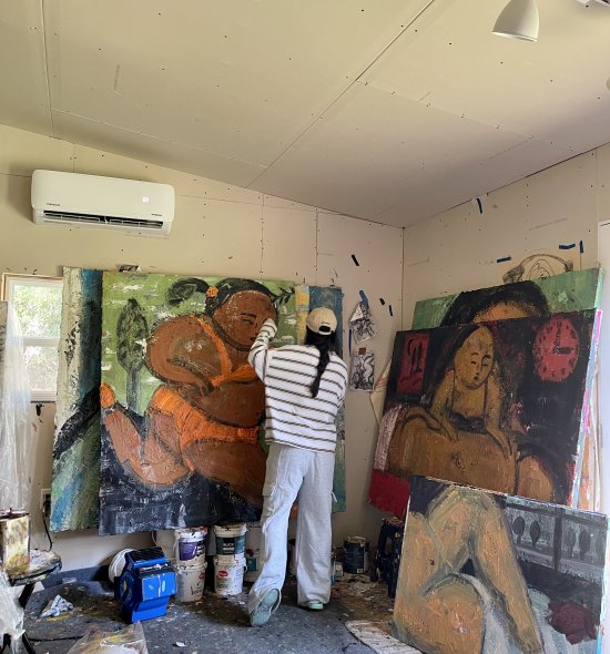 An artist working on a large painting